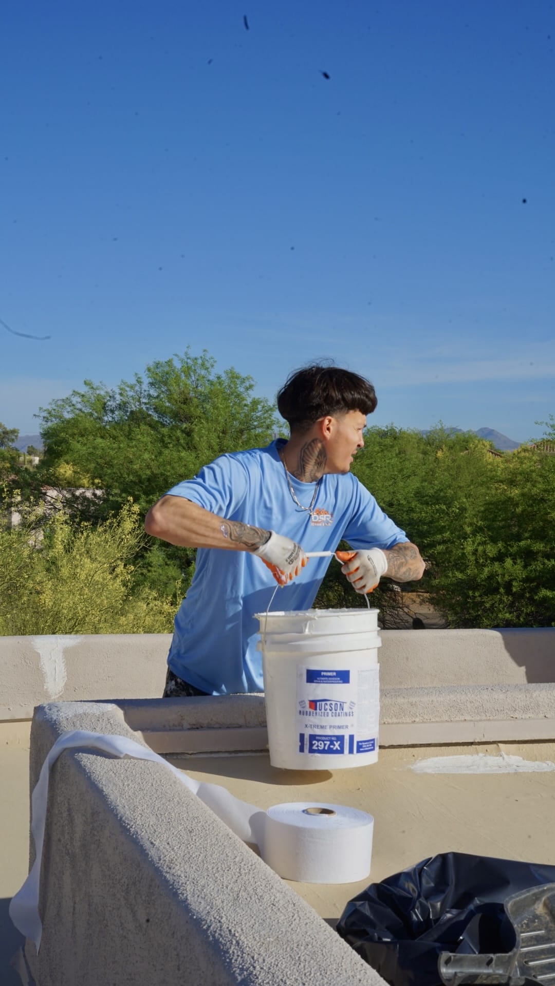 DSR Roofing crew member prepping Tucson Rubberized primer on a Tucson flat roof