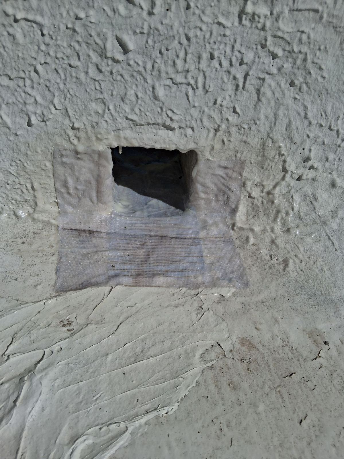 Polyester fabric set into primer around a scupper on a Green Valley flat roof